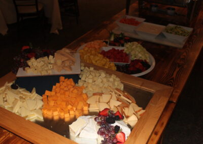 A tray of cheese and fruit on a table.