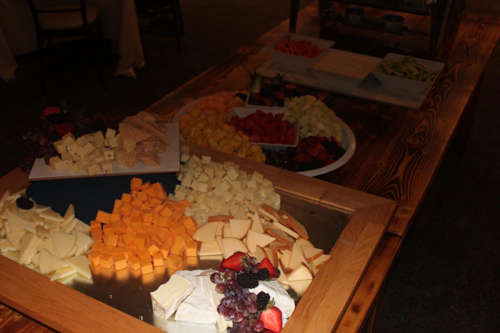 A table with a lot of cheese and fruit on it.