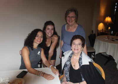 Three women posing for a picture at a table.