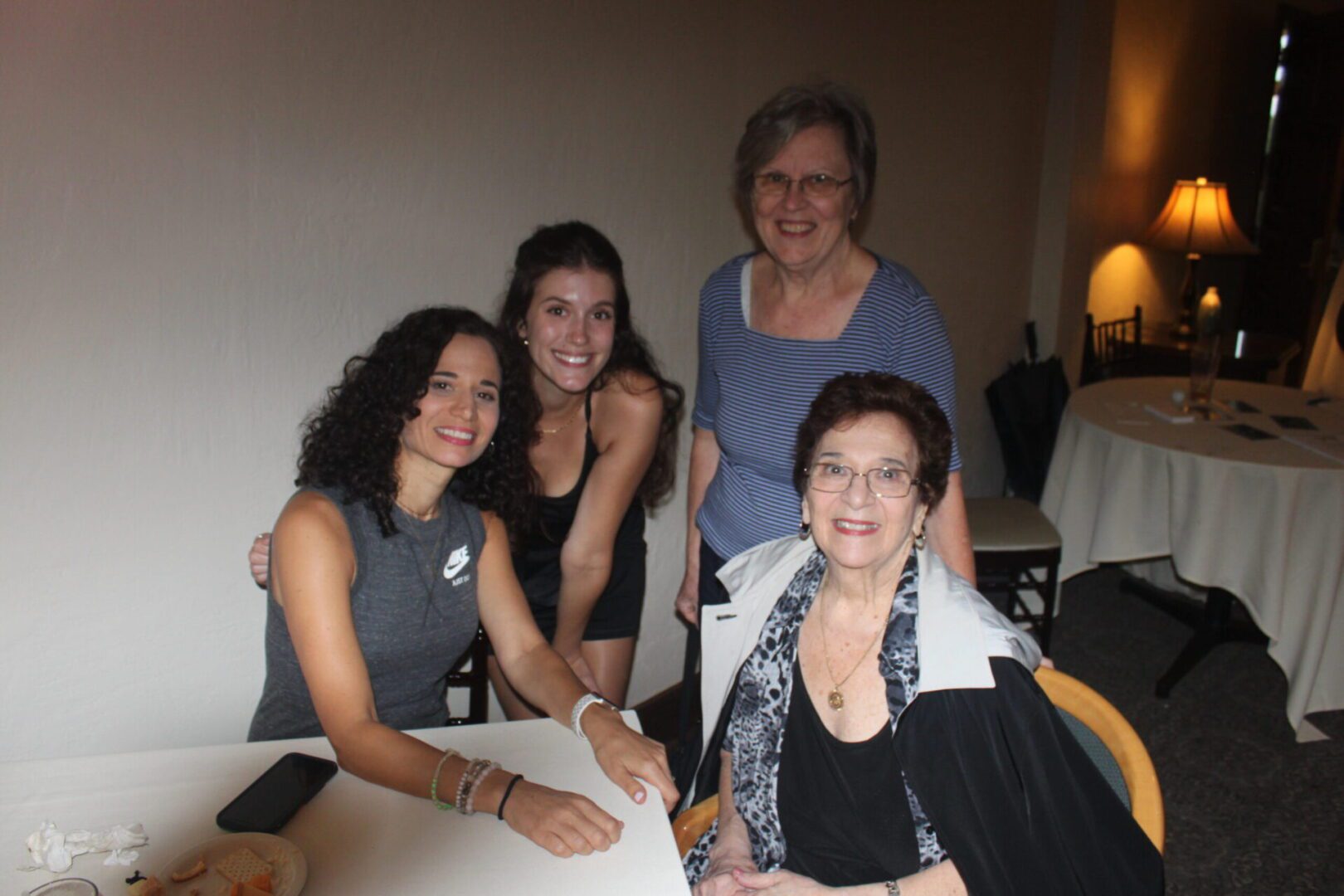 Three women posing for a picture at a table.