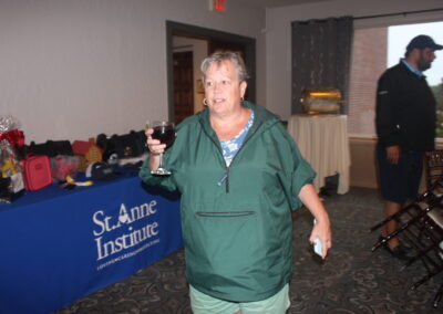 A woman holding a glass of wine.