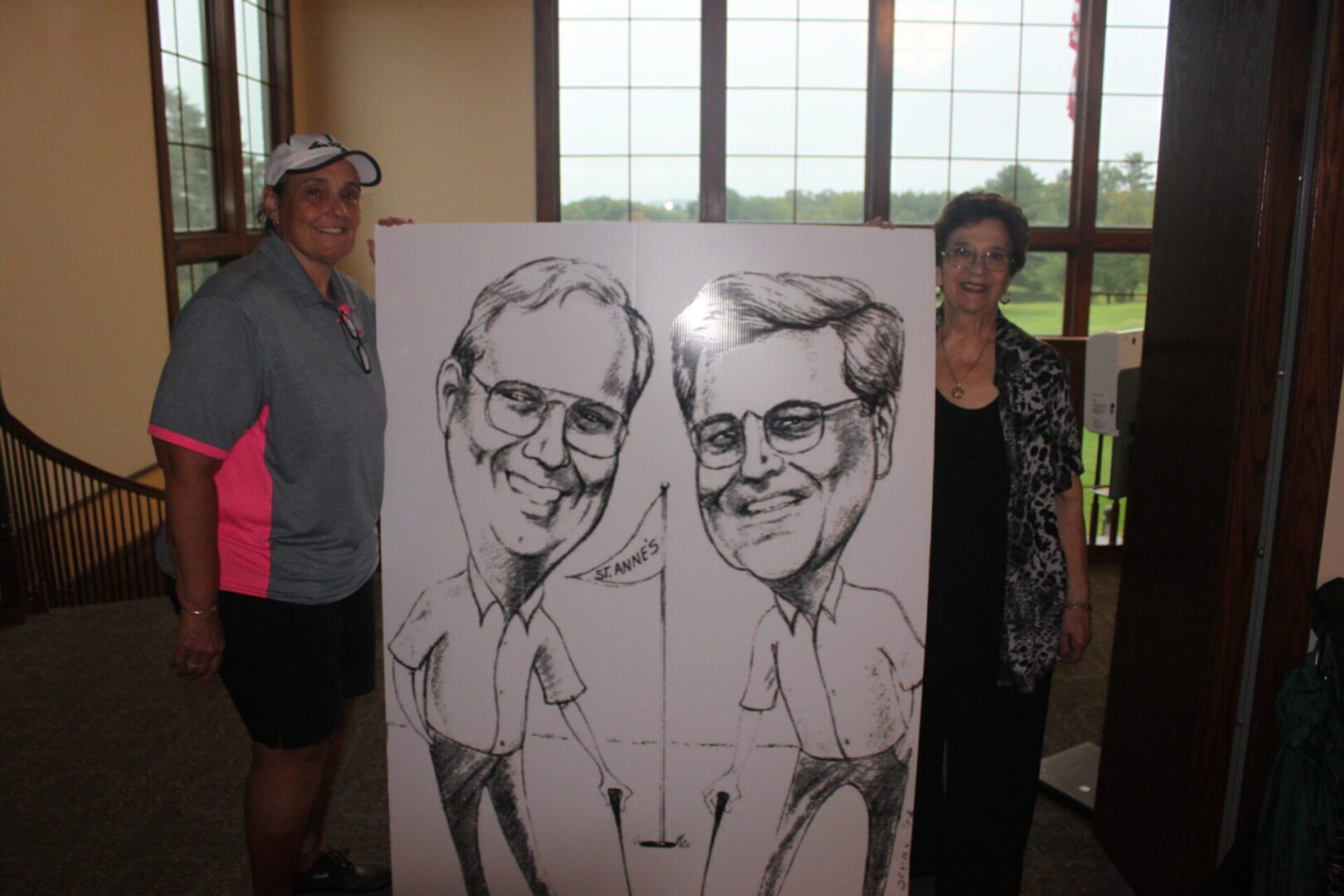 Two people standing next to a caricature.