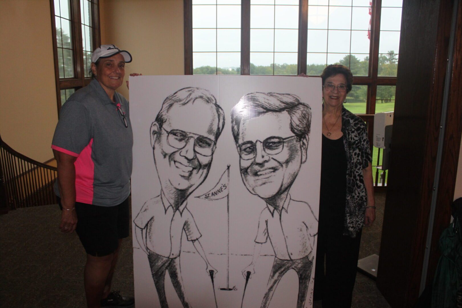 Two people standing next to a caricature.