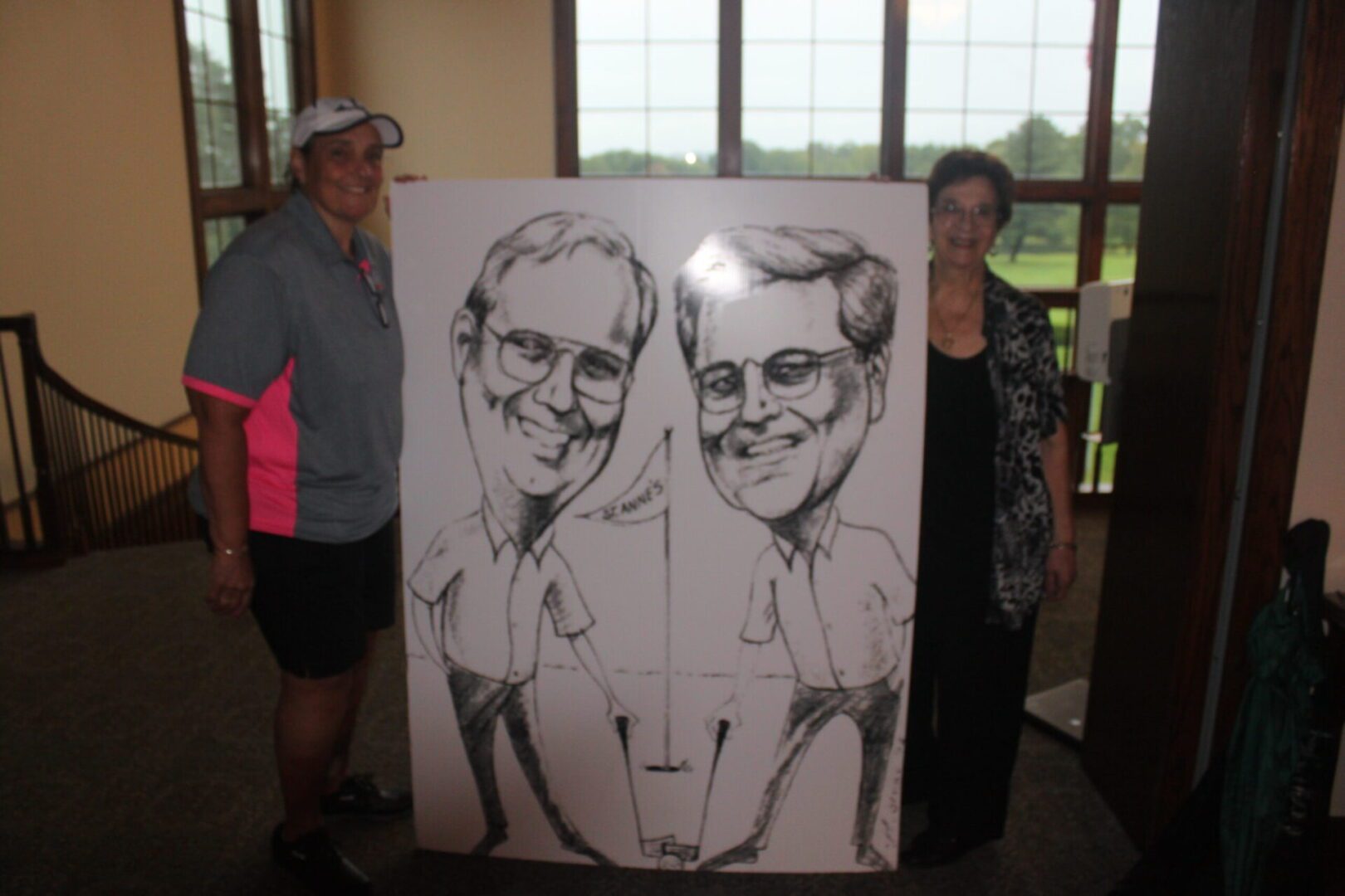 Two people standing next to a caricature.
