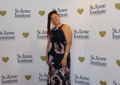 A woman in a floral dress standing in front of a heart shaped wall.