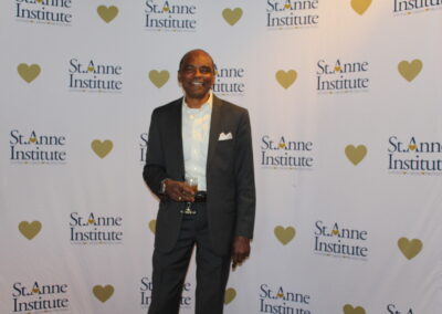 A man in a suit standing on a red carpet.