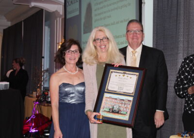 A woman holding a framed award.