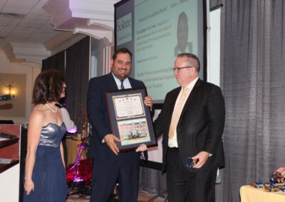 A man holding a framed certificate.