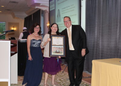 A woman holding a framed certificate.