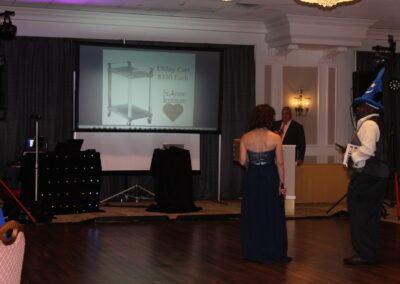 A man and a woman standing in front of a projection screen.