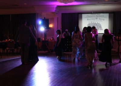 A group of people dancing on a wooden floor.