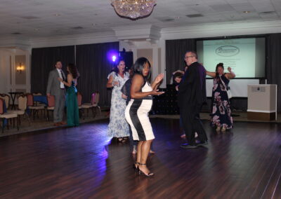 A group of people dancing on a wooden floor.