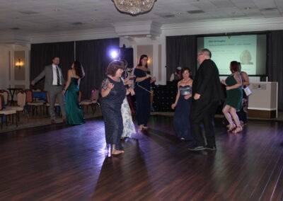 A group of people dancing on a wooden floor.