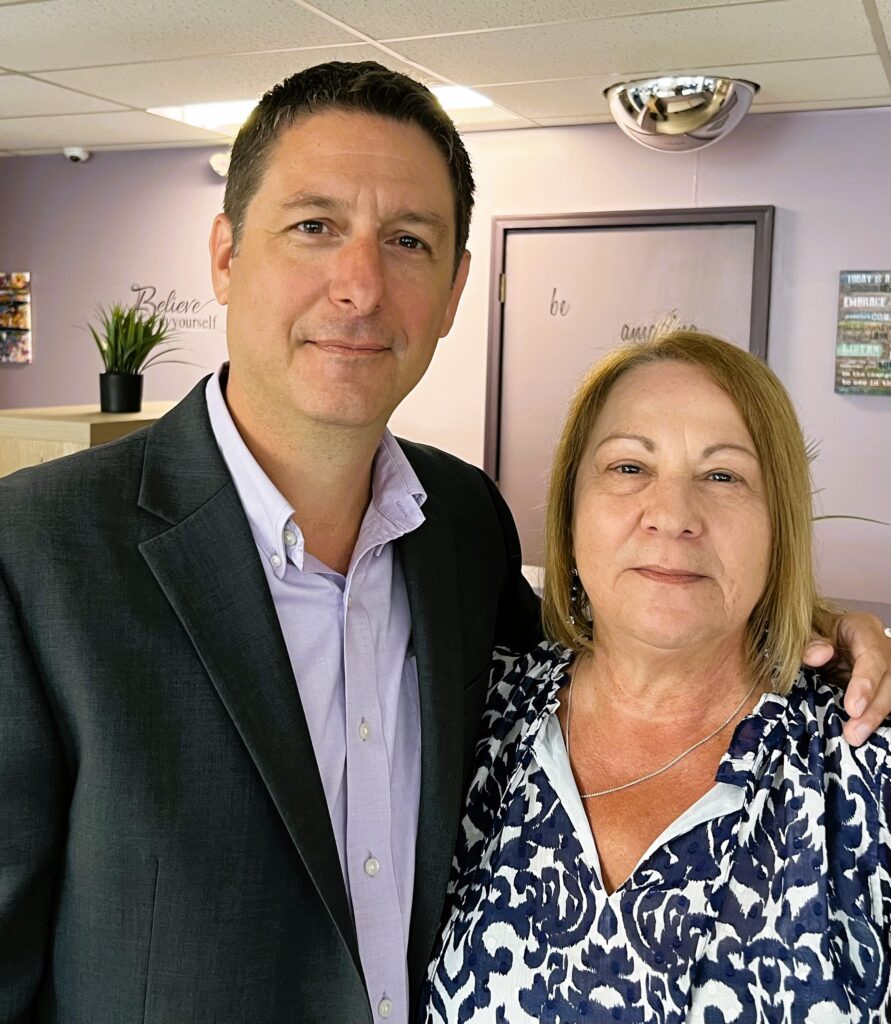 A couple standing together smiling at the camera