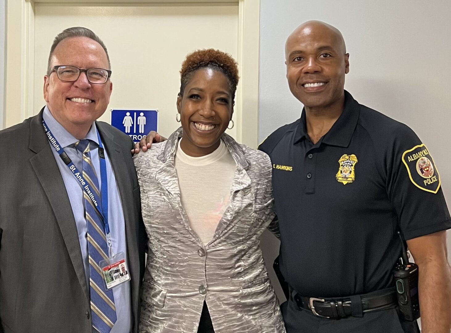 Two people along with a police officer smiling at the camera