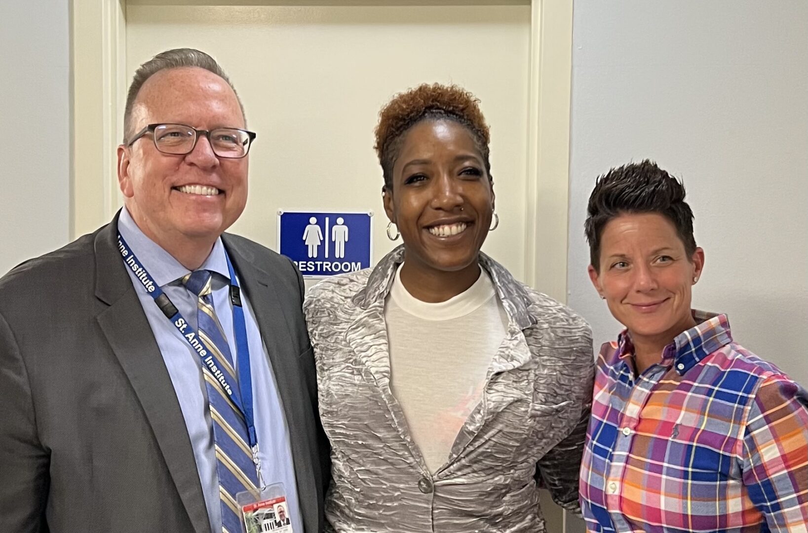 Two people along with a lady officer, smiling at the camera