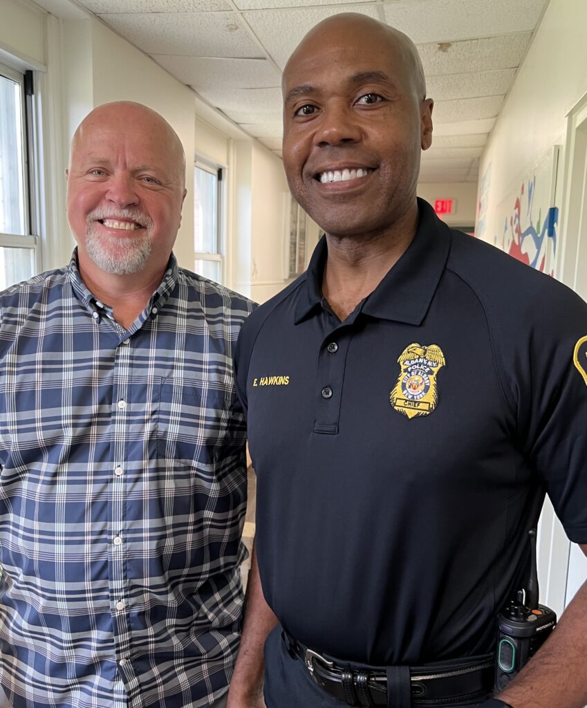A man standing with a police officer smiling at the camera
